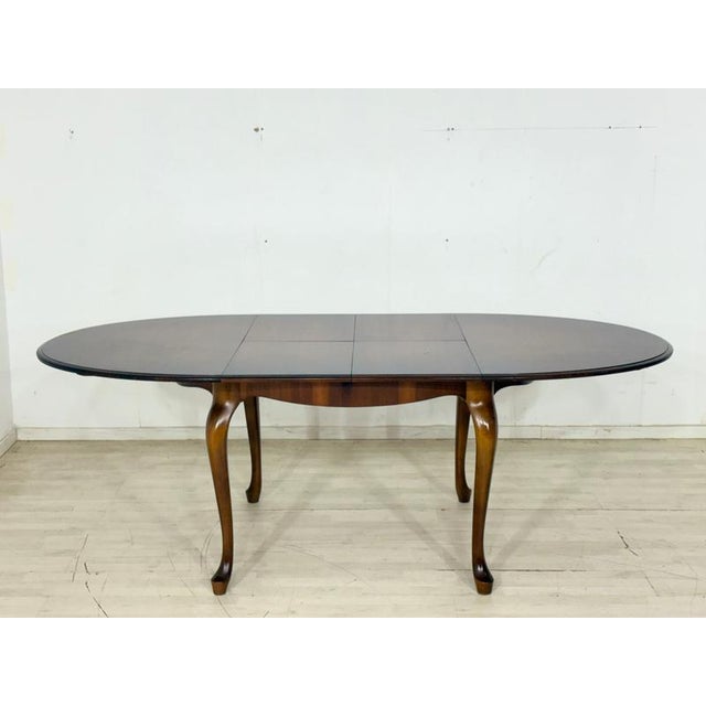 For sale is a beautiful, oval dining table made of high-quality solid wood, distinguished by its classic curved legs...