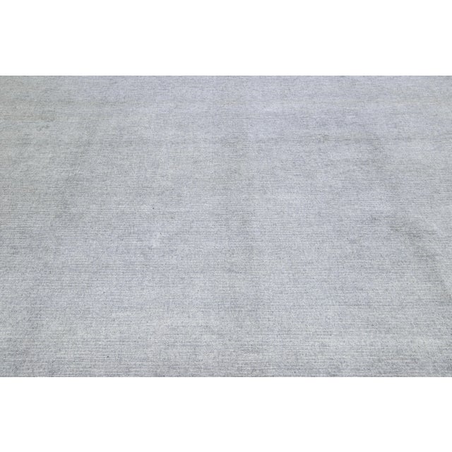This exquisite contemporary wool and silk rug showcases a striking gray-silver base adorned with a stunning geometric...