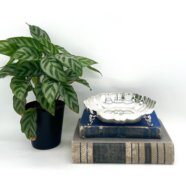 Classic vintage silverplate bowl by Oneida featuring a softly scalloped rim and raised on three decorative scroll feet....