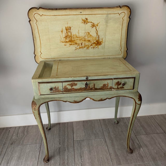 This antique desk or vanity has patina in all the right places, a key that works and a tonal brown decoration on a dusty...