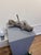This mixed media piece presents a weathered piece of wood, punctuated by a lone rusty nail, evoking themes of decay and...