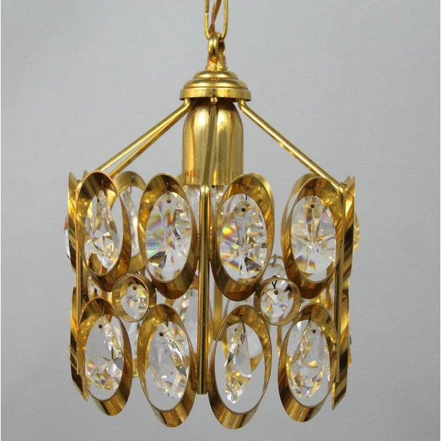 This ceiling light is reminiscent of the designs by Gaetano Sciolari and is made of golden metal and carved crystals. It...