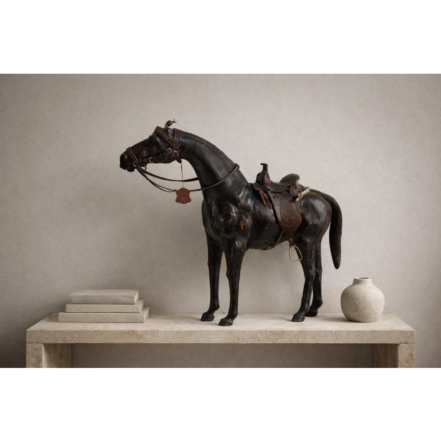 Monumental leather horse sculpture clad in richly patinated leather and fitted with detailed Western tack. A striking...