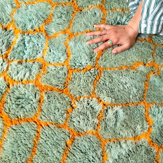 A playful, high-energy lattice — turquoise trellis patterning frames a bold central band of solid orange, all traced...