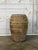A highly characterful terracotta storage vessel distinguished by its strong ribbed form and richly encrusted surface. The...