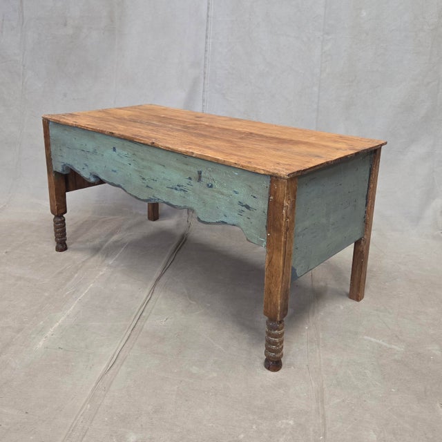 A charming vintage rustic pine coffee table with a teal painted base and turned legs. The front apron of the table was...