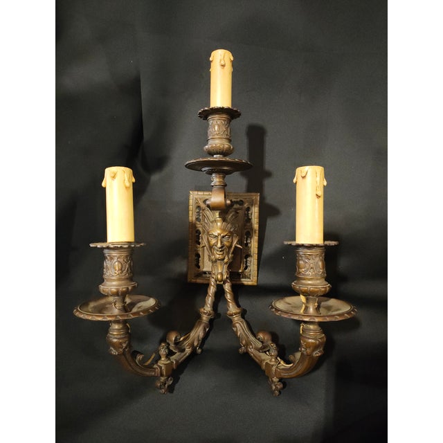 An impressive pair of late 19th century French Renaissance Revival bronze wall sconces featuring dramatic grotesque...