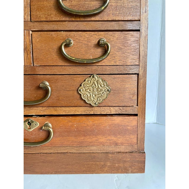 Here is a vintage Japanese tansu-style jewelry chest dating to the 1960s–1970s. Crafted in warm-toned wood, the petite...