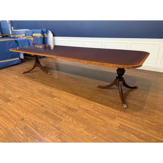 This is a multi-banded mahogany dining table by Leighton Hall. It features a field of cathedral mahogany with exotic...