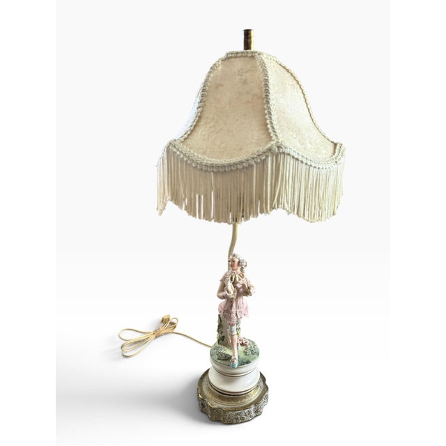 An ornate vintage figural table lamp featuring a beautifully detailed porcelain figure in an elegant 18th-century/Rococo-...
