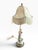 An ornate vintage figural table lamp featuring a beautifully detailed porcelain figure in an elegant 18th-century/Rococo-...