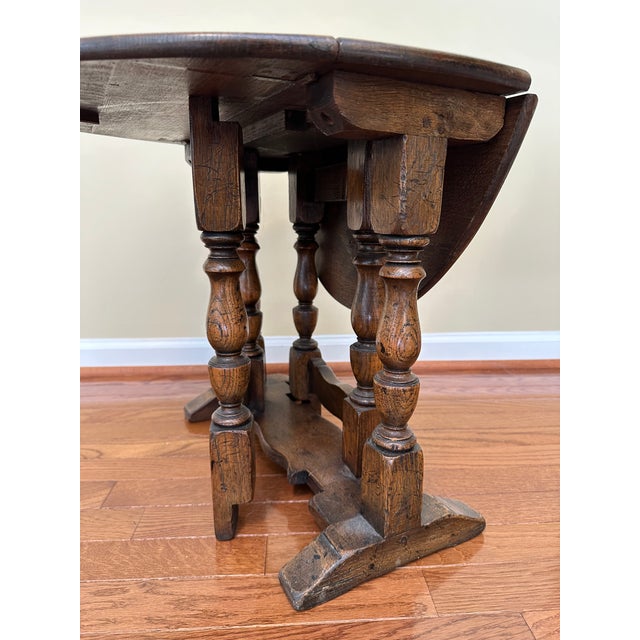 18th century English gateleg side table of dark brown wood and turned legs. Table width is 20.5" expanded and 7" closed.
