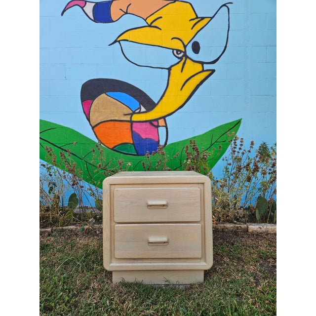 A sculptural vintage nightstand by Keller featuring soft rounded edges, integrated wood pulls, and a warm bleached finish...
