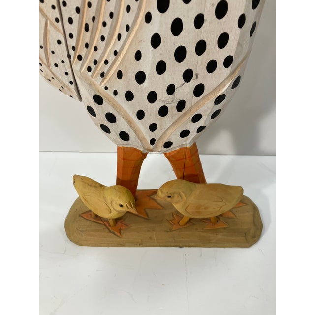 This carved wood chicken & chicks is hand painted. The tail is attached to the body by string This is carved pine