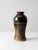 This vintage studio art pottery vase is a hand-crafted ceramic piece featuring a rich deep brown glaze accented by a...