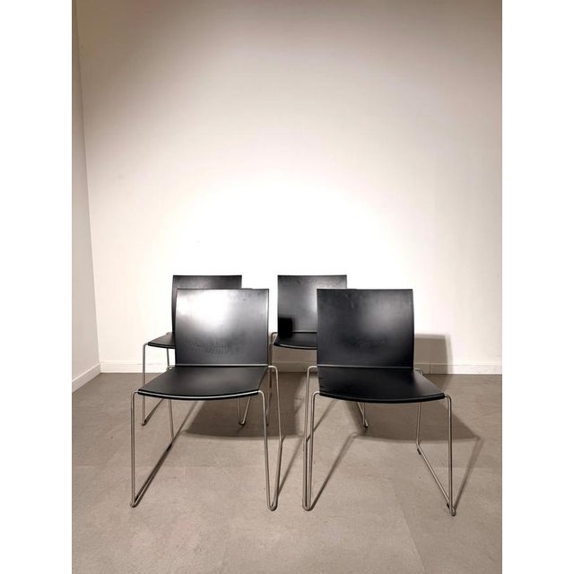 Elegant set of four minimalist dining chairs by MDF Italia , featuring a refined architectural design with clean lines and...