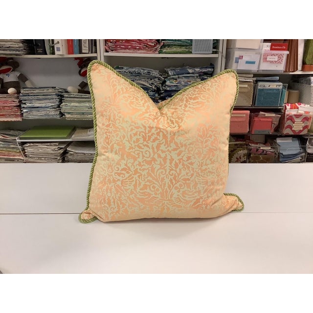 Two 21" square down filled pillows in peach and cream Fortuny-style fabric and one 14" X 4" down filled bolster in peach...