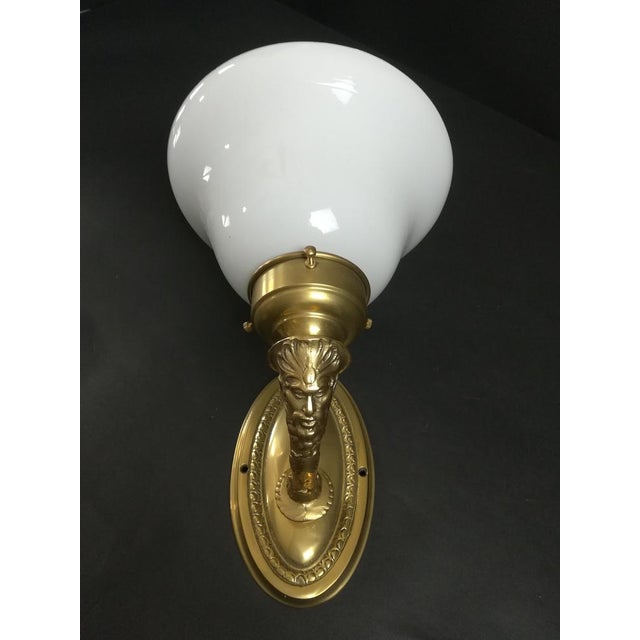 Solid brass wall lamp with opal overfang glass shade. The lamp gives a cozy non -dazzling light. Surface polished. Rewired...