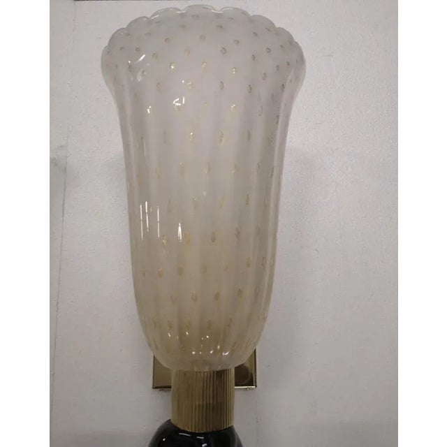 Refined and delicate design for this pair of wall light with black and cream color Murano glass. The pair of wall light...