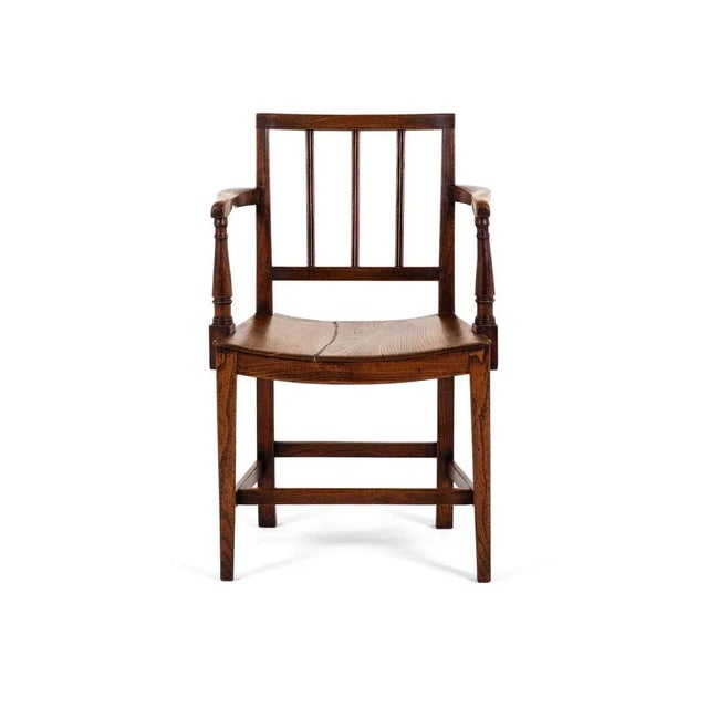A lovely east anglian open armchair in elm with wide open and turned uprights. The chair has a welcoming square back with...