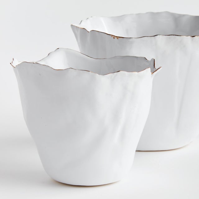 With crimped edges and natural form, this set of cachepots is a real statementmaking centerpiece. The handbrushedGold...