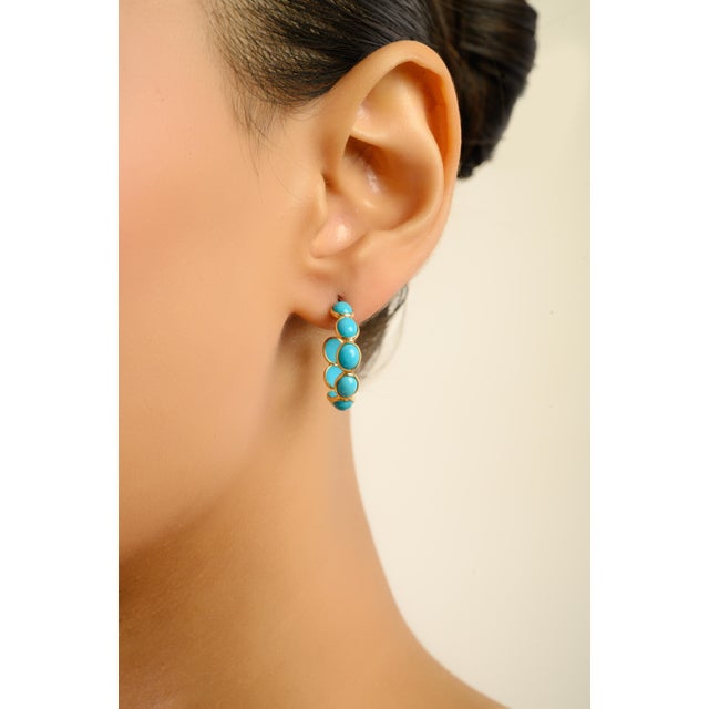 These elegant hoop earrings showcase 1.25 carats of natural cabochon turquoise, each stone measuring approximately 4.3 x...