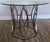 Couture Glass Top Round Dining Table featuring an intricate geometric stainless steel base and a clear floating glass top