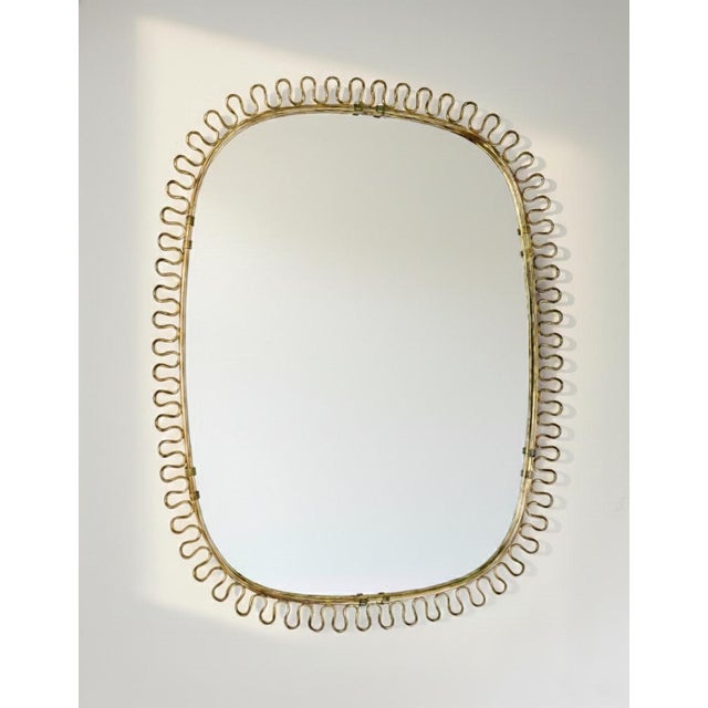 This elegant brass mirror was designed in the 1950s by Austrian designer Josef Frank for the renowned Swedish design...