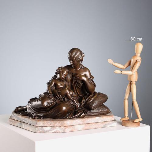 Bronze sculpture on a marble base depicting an intimate moment between a mother and her sleeping son. Engraved signature....