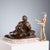 Bronze sculpture on a marble base depicting an intimate moment between a mother and her sleeping son. Engraved signature....