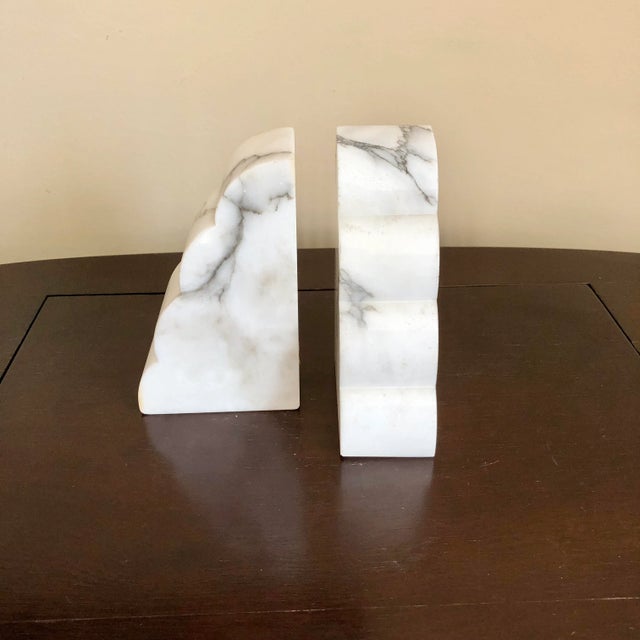 A pair of mid century carved white alabaster bookends with dark grey veining. Made in Italy.