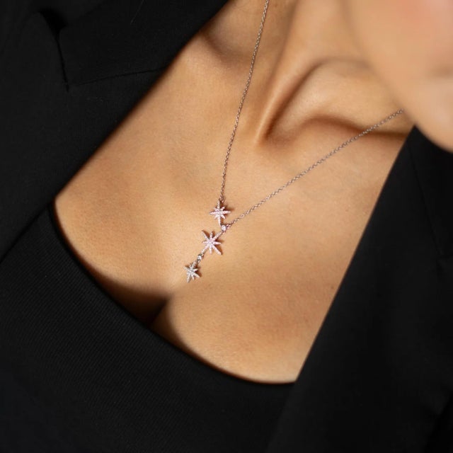 Shine like the night sky with our Celestial Cascade Silver Necklace. Featuring three dazzling star charms adorned with...