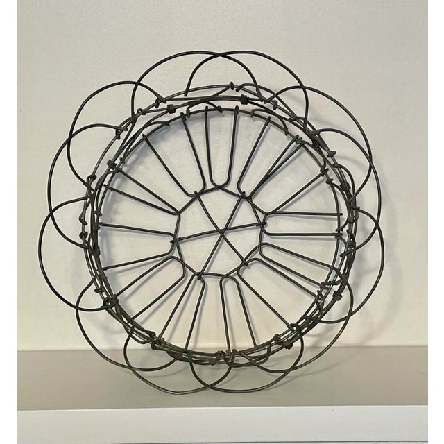 A small French Country inspired wire basket in a neutral, gray color. This versatile, adjustable basket could be...