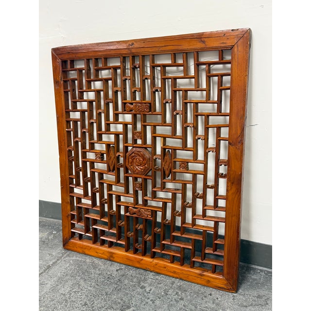 Design Plus Gallery presents an Antique Chinese Carved Wood Lattice Panel. The frame surrounds a repeating geometric...