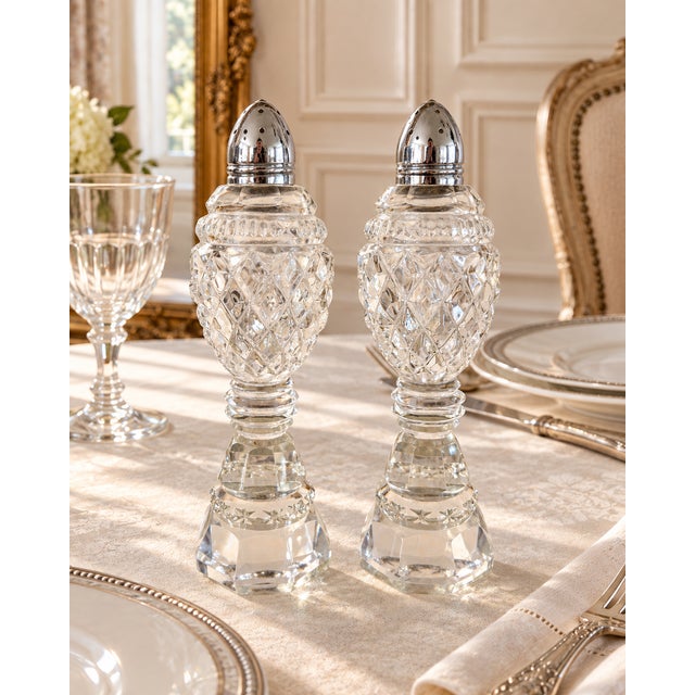 Each shaker features faceted diamond and starburst detailing, a ringed stem, an octagonal base, and a pointed silver-tone...