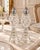 Each shaker features faceted diamond and starburst detailing, a ringed stem, an octagonal base, and a pointed silver-tone...