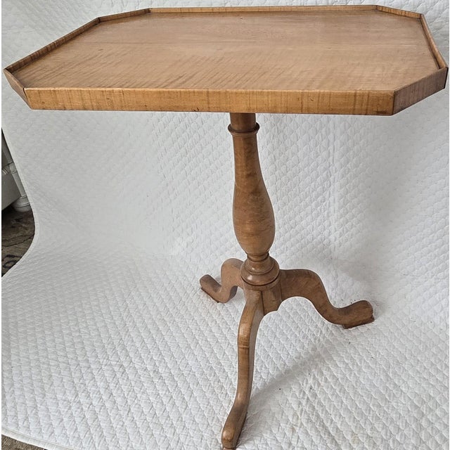An early 19th century American tilt-top candlestand featuring a shaped rectangular top with gently chamfered corners and a...
