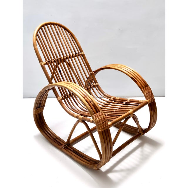 Made in Italy, 1970s. This rocking chair features a bamboo frame and its patterned fabric cushion, which has a soft...