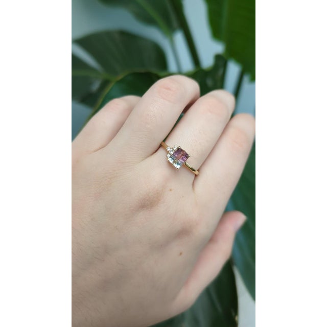 This delicate ring showcases a 1.00-carat emerald-cut Bi-Color Tourmaline from Brazil, known for its unique natural color...