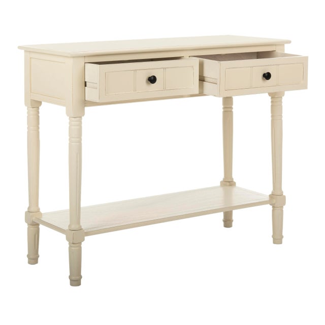 The console, in a distressed cream finish, wraps a inviting country charm around ample storage, which includes two drawers...