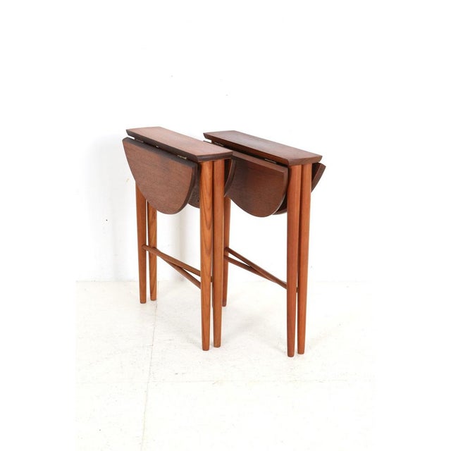 Denmark, 1960s, design: Carlo Jensen for Poul Hundevad. Delicate teak side tables. Foldable for space-saving storage when...