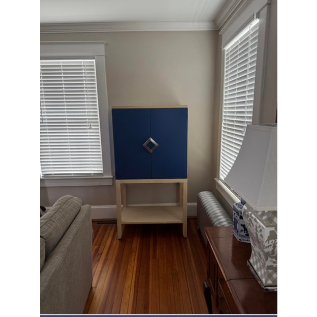 Designed by Wildwood natural raffia. The inside of the cabinet features a mirrored back, rack for 12 wine glasses, shelf...