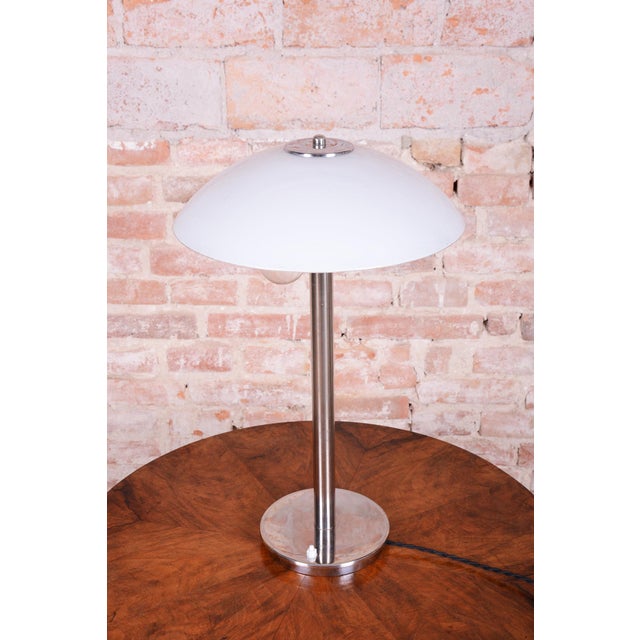 This elegant table lamp is a classic example of the Bauhaus style and was manufactured in Czechoslovakia during the 1930s....