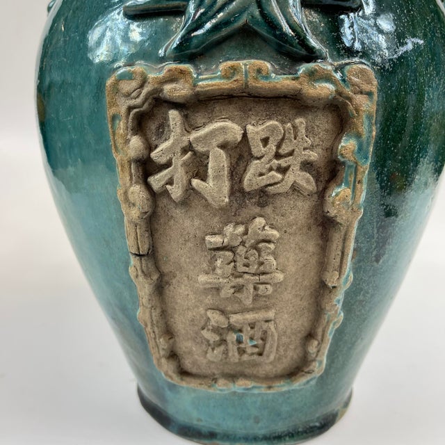 A beautiful and unusual wine jug in a turquoise and blue glaze. The front panel with Chinese writing indicates a type of...