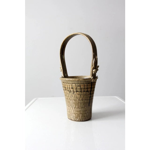 Handcrafted vintage studio pottery vase by Frank Polizzi, designed in a basket form with a decorative top handle. Finished...