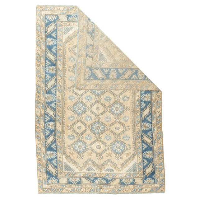 The straw field displays a three column lattice of hooked hexagons in light blue. Ecru zig-zagged end panels. Medium blue...