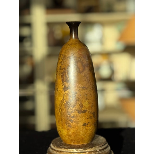 A striking example of Japanese mid-century bronze craftsmanship, this elegant bottle vase features the coveted Murashido...