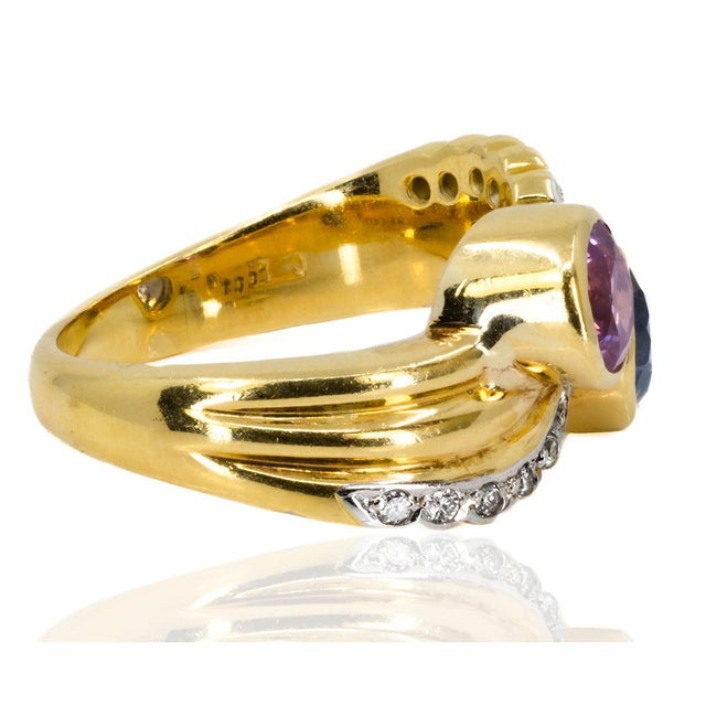 Hand fabricated ring by Keith Davis containing one round blue sapphire weighing 1.25 carats and ne round pink sapphire...