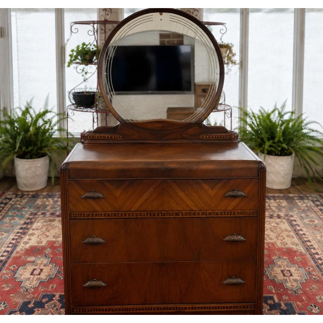 An elegant American Art Deco waterfall vanity dresser dating to the 1930s, crafted with beautifully figured walnut veneers...