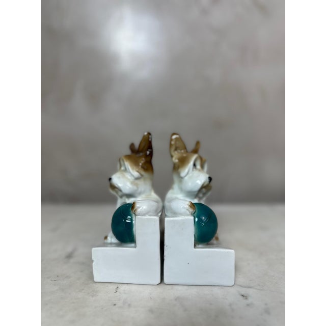 Adorable pair of bookends depicting two finely sculpted terrier dogs in glazed porcelain, dating from the 1930s. Each dog...